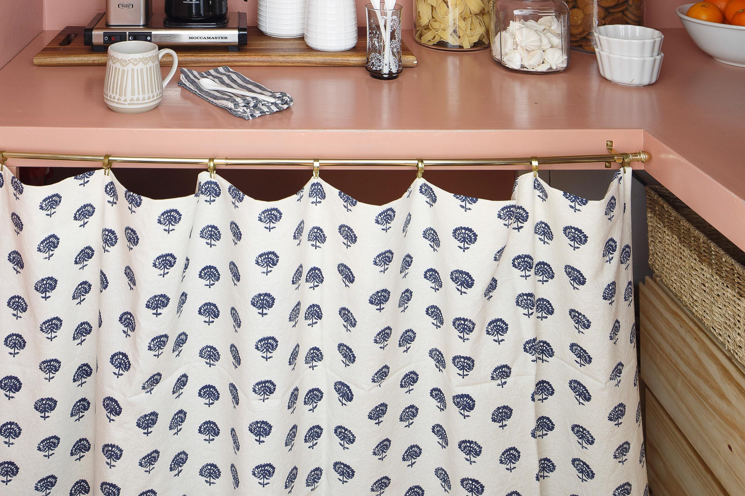 curtain hiding messy storage under counter in a kitchen