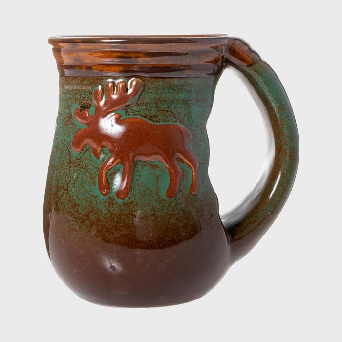 Mug features a textured moose design, combining earthy brown and green tones, with a handle in a simple studio setting.
