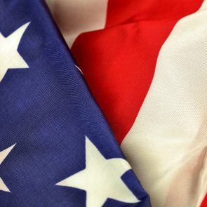 Flag shows stars and stripes, with intersecting blue, white, and red sections, conveying a patriotic theme.