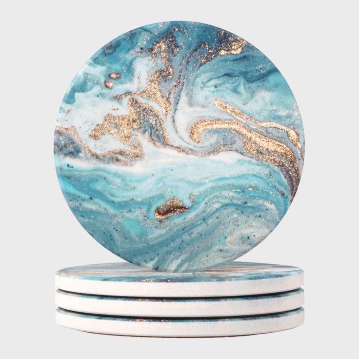 Circular coasters display swirling blue and gold marbled patterns, stacked neatly against a plain background.