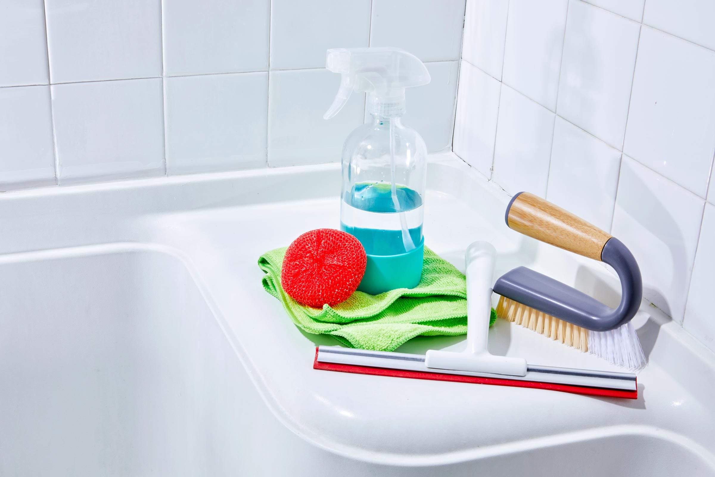 spray bottle, sponge, towel, cleaning brush in a shower for removing hard water stains
