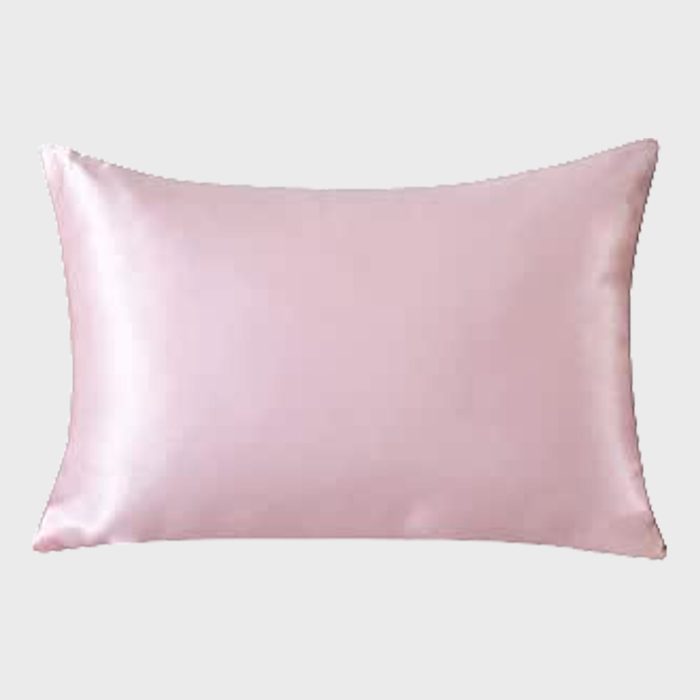 Pink satin pillow sits against a plain gray background, displaying a smooth and shiny texture.