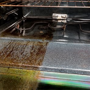 Oven interior showing a stark contrast between the cleaned and dirty sections, displaying the effectiveness of cleaning in a kitchen environment.