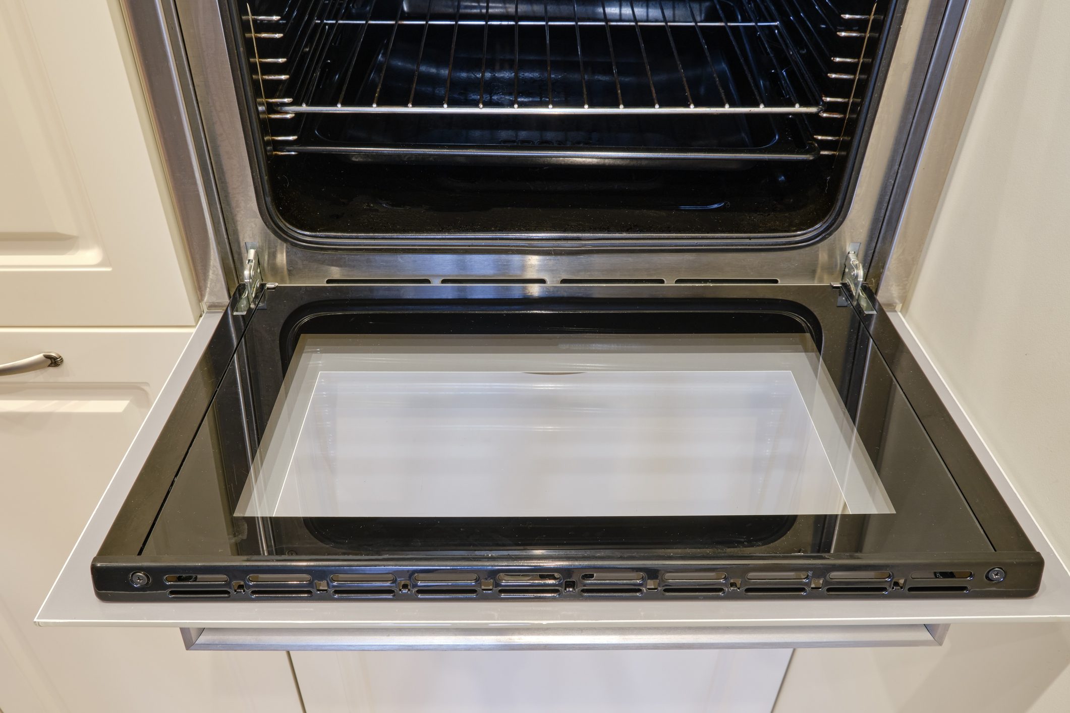 A clean oven with washed glass built into the furniture in the home kitchen