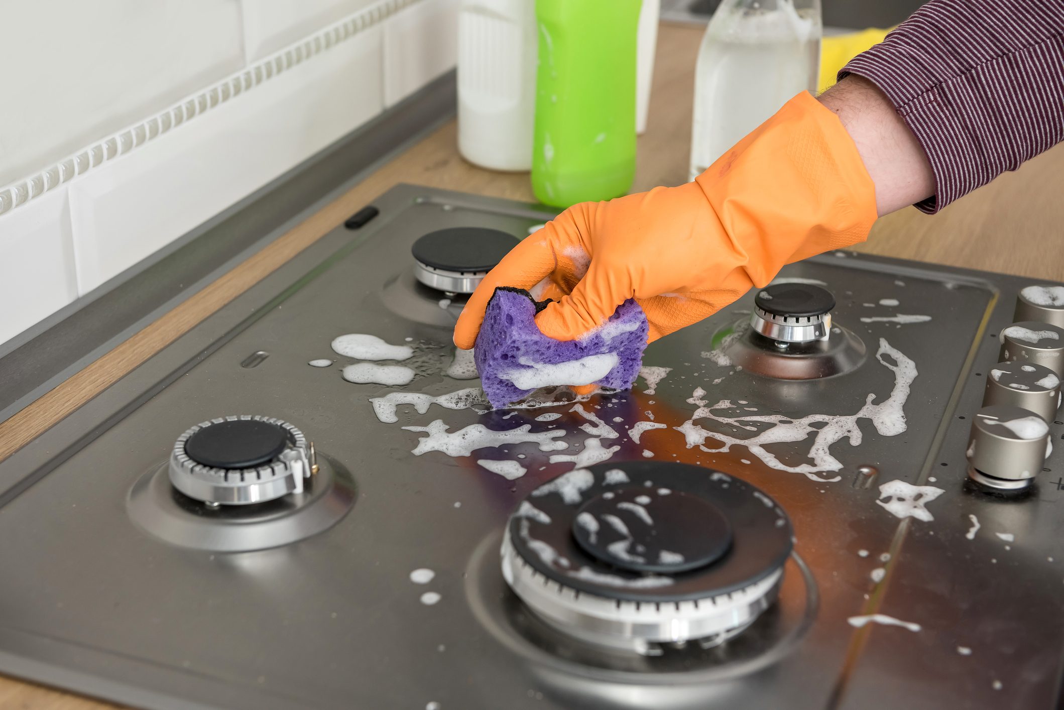 Cleaning in the kitchen gas stone with foam and sponge