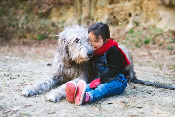 young girl sitting outside with her irish wolfhound