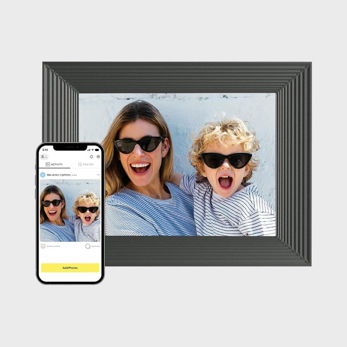 Smartphone displays a photo of a smiling pair wearing sunglasses, alongside a large framed version against a simple background.