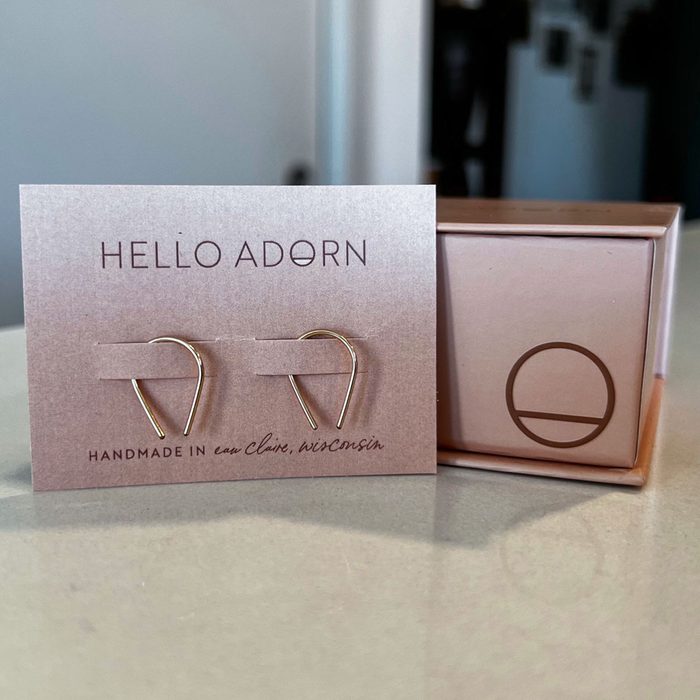 Earrings rest on a display card labeled 