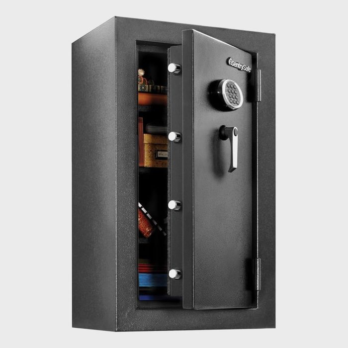 Safe door is slightly open, revealing shelves with miscellaneous items inside, against a plain backdrop.