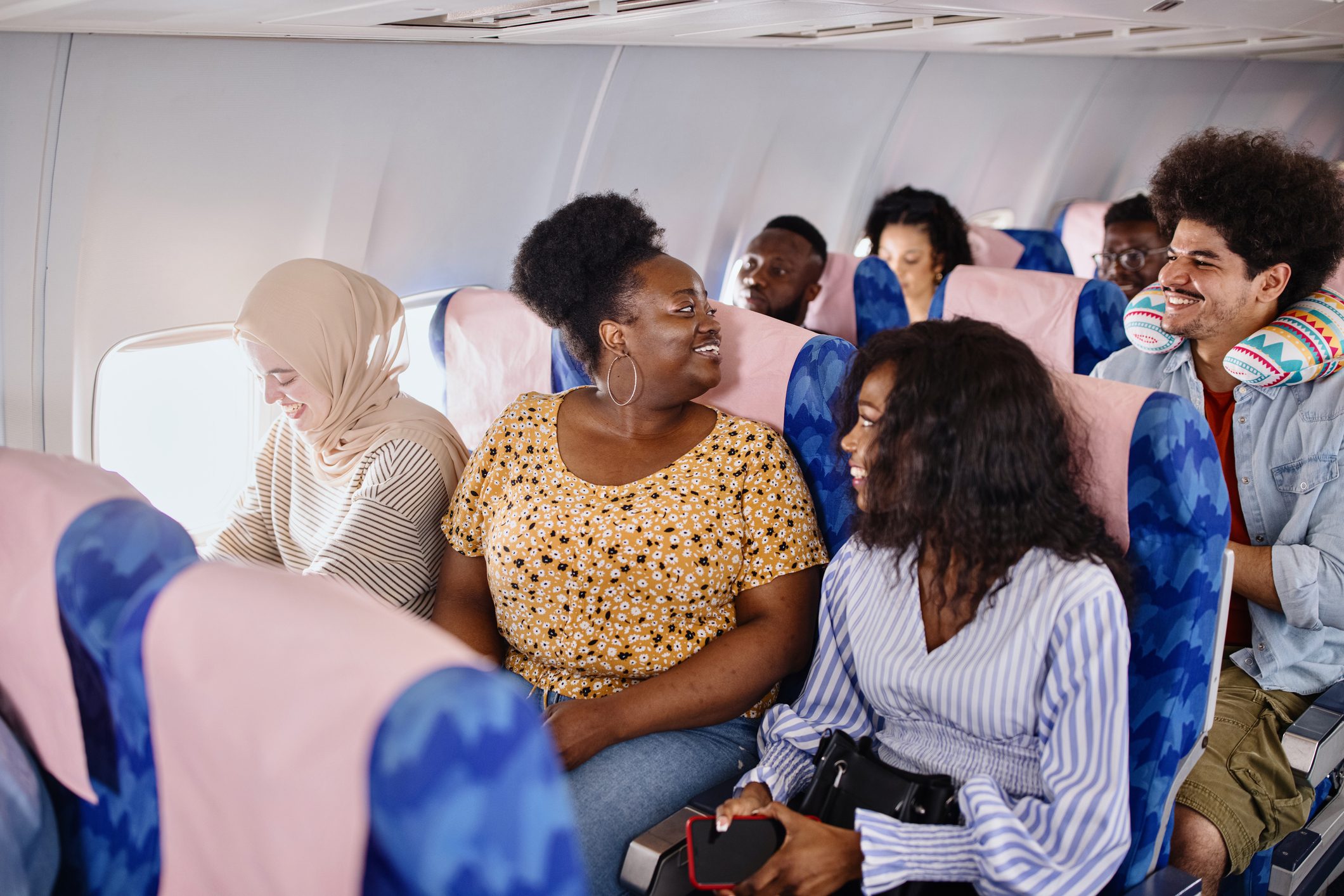 Friends take their seats, excited for their summer holiday.