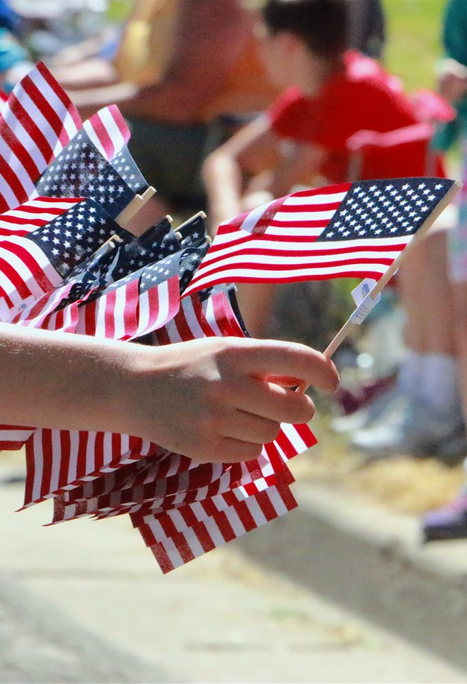 Hand Passing Out American Flags at a fourth of july Parade
