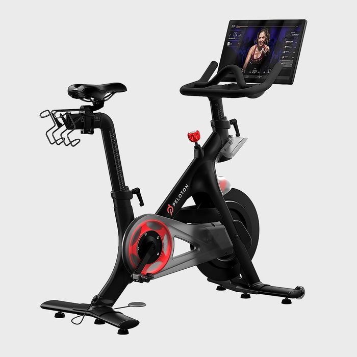 Exercise bike displaying workout video, situated indoors.