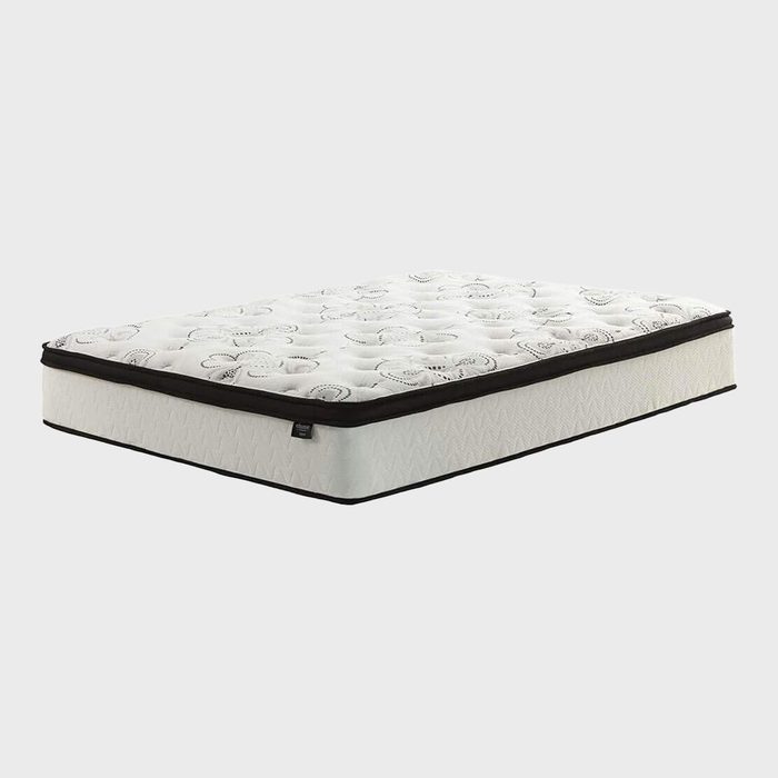 Mattress lying flat, featuring a white surface with subtle patterns, black trim, against a plain gray background.