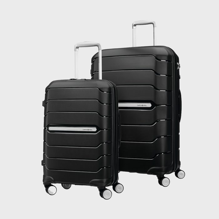 Two black suitcases stand upright; they have four wheels and extendable handles. The background is plain white. They feature the text 
