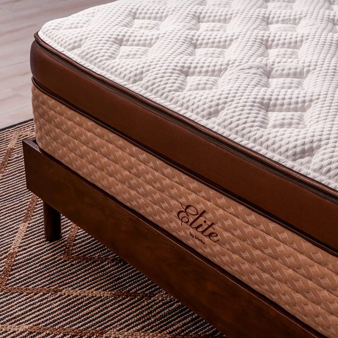 Mattress rests on a wooden bed frame; 