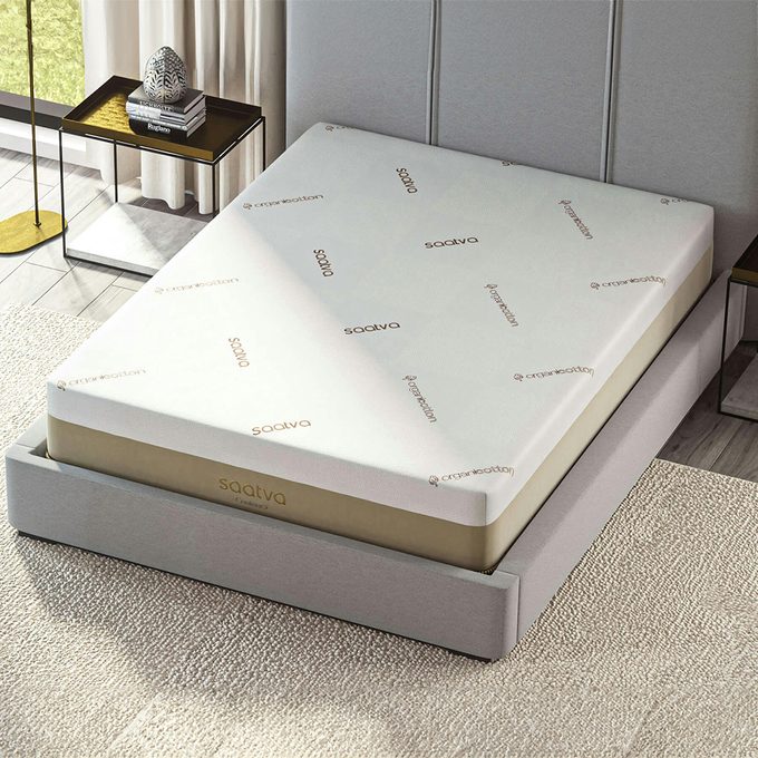 Mattress lies on a bed frame, displaying brand logos 