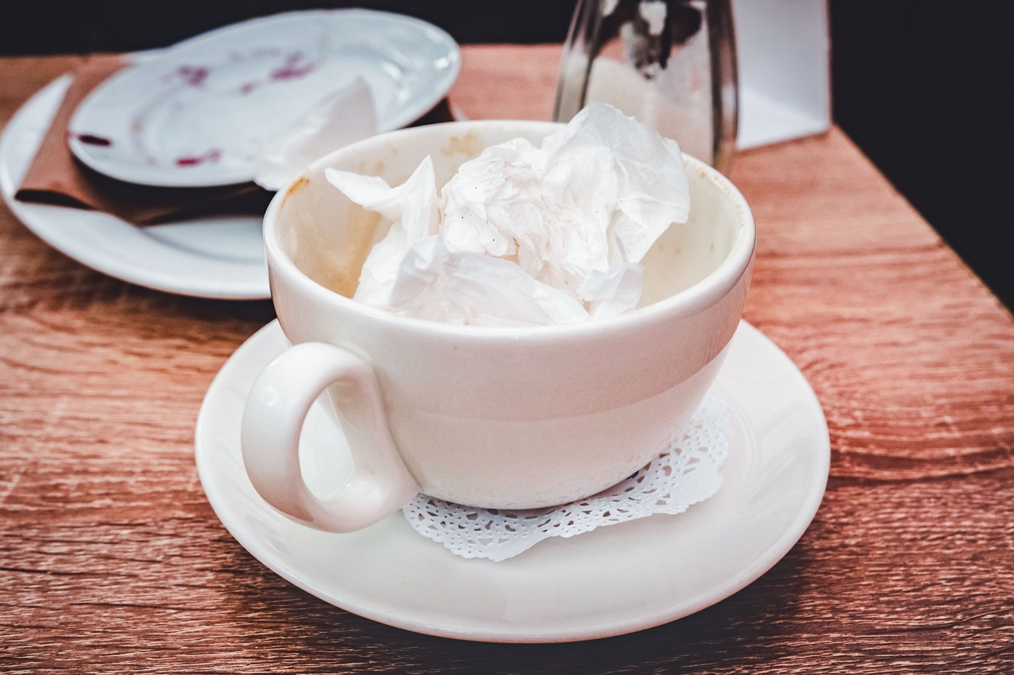 Empty Cup Filled With Napkin After Drunk Coffee On A Wooden Table