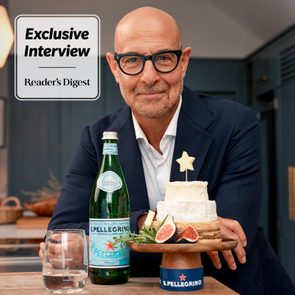 A man with glasses sits smiling beside a bottle and a cheese platter. Text reads: 