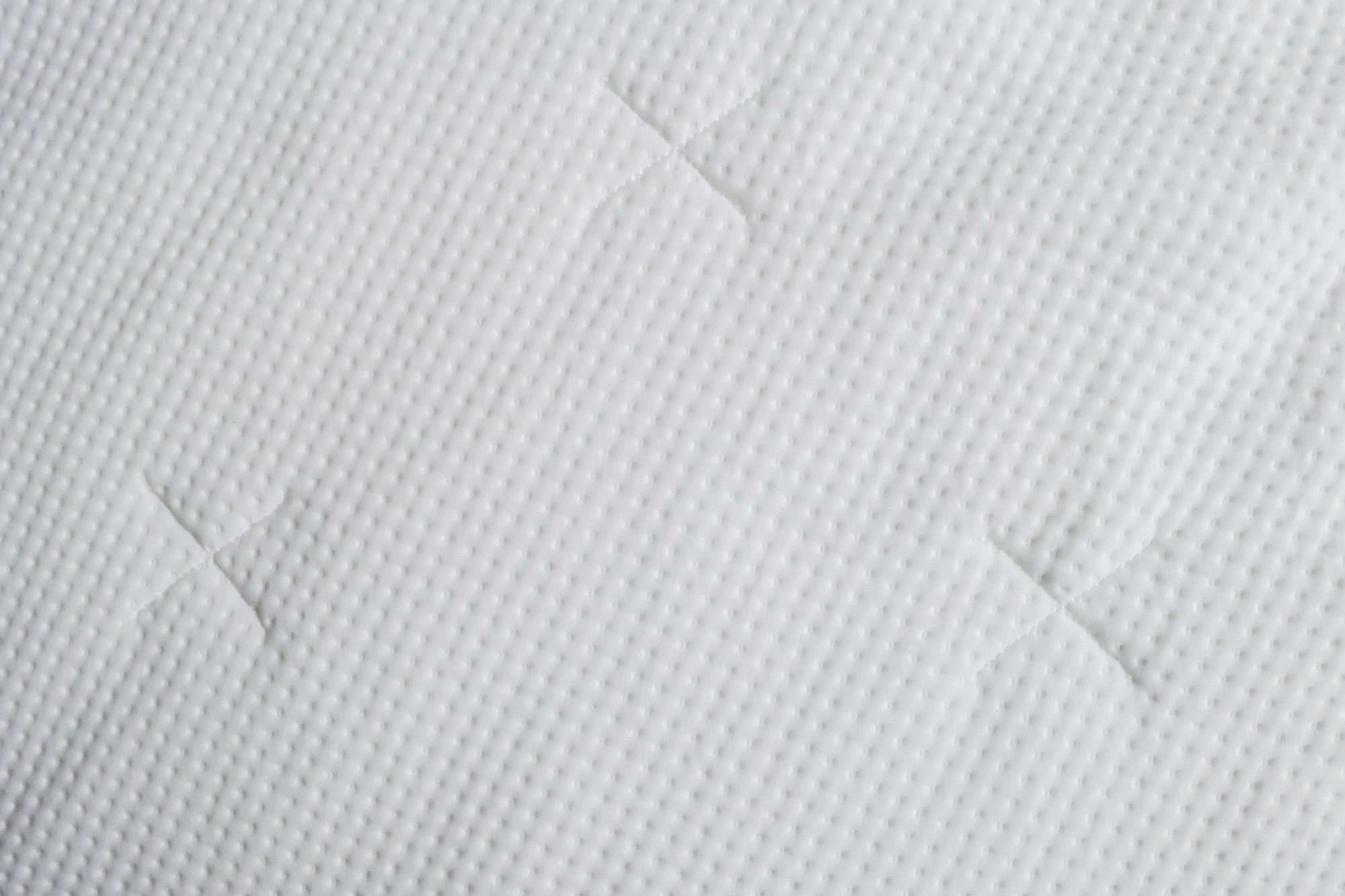 White textured surface features small, raised, repetitive dots and subtle diagonal cross patterns, creating a grid-like appearance across the entire image.