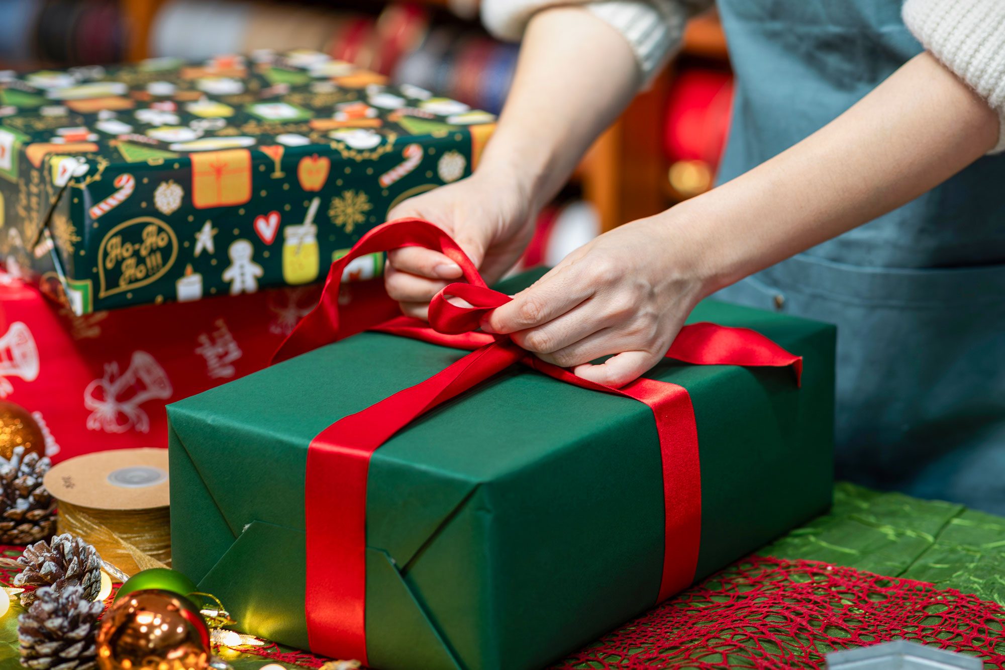 Retail Clerks Wrapping Gift In Christmas Decoration Store
