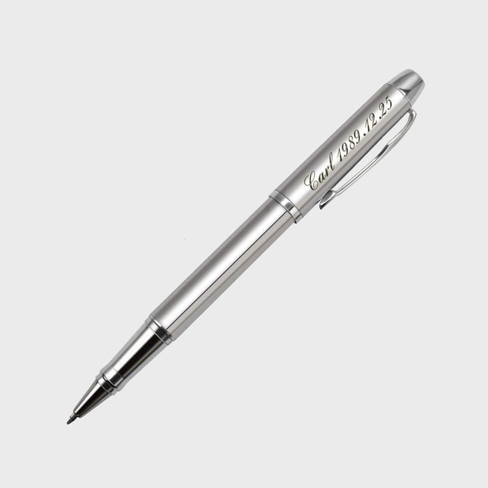 Silver pen lies diagonally; inscribed text reads 