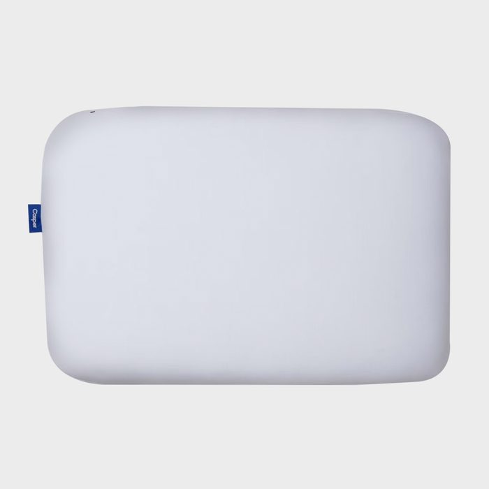 White pillow laying flat with a small blue tag labeled 