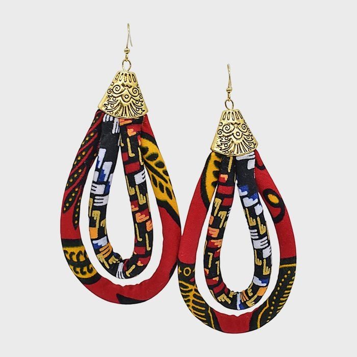 Earrings hang gracefully, featuring colorful fabric loops with intricate patterns and ornate golden tops, set against a plain white background.