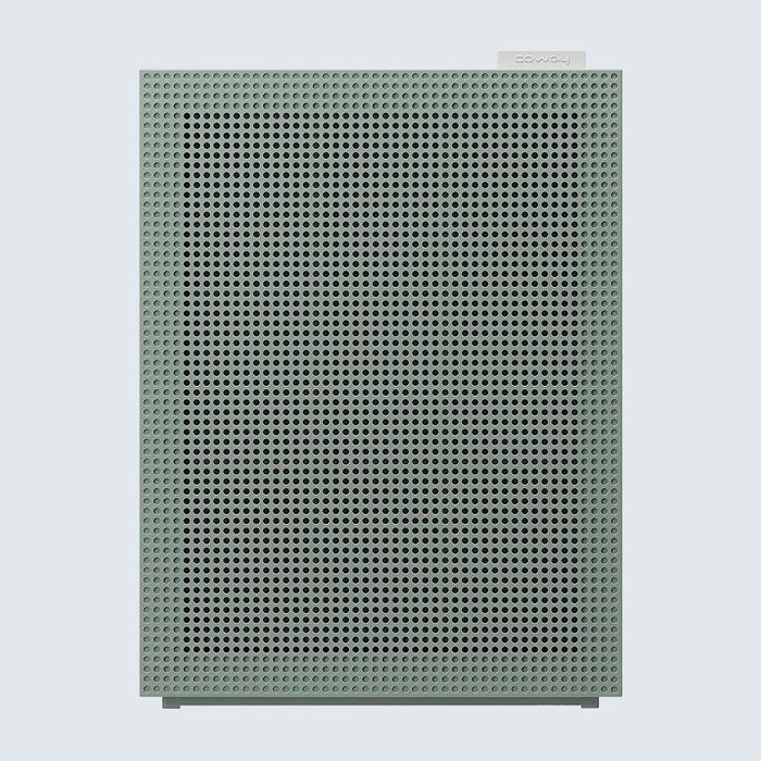 Rectangular air purifier standing, featuring a perforated front panel, set against a plain light background. 