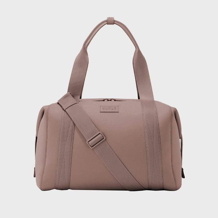 A beige duffel bag with handles and a strap, is displayed, against a plain white background.