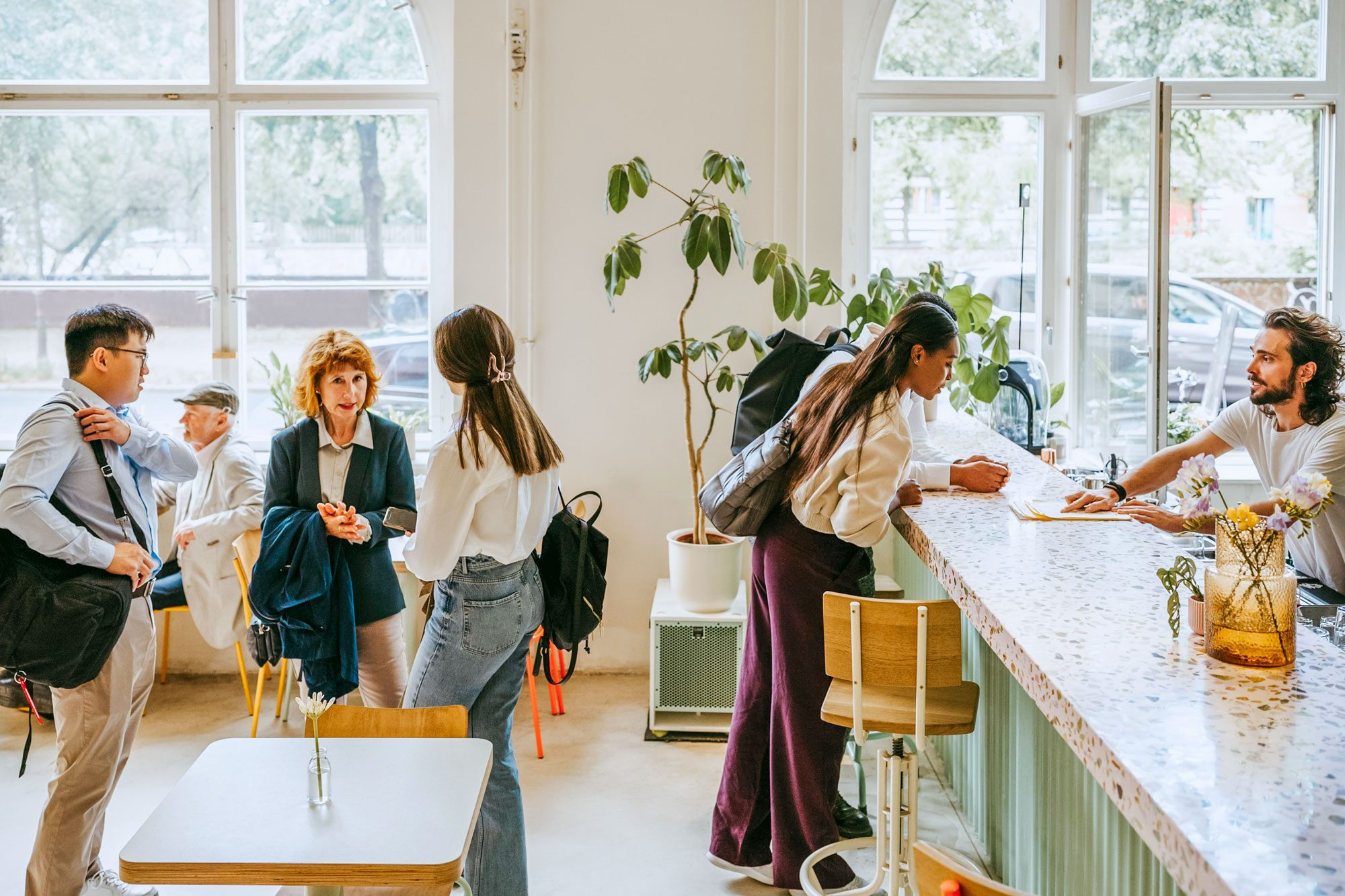 Friends Waiting In Line While Customers Ordering To Restaurant Owner