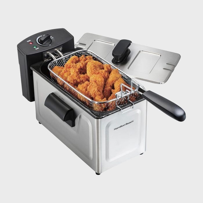 Deep fryer holding fried food in a metal basket, located in a kitchen appliance setting, appears ready for use.