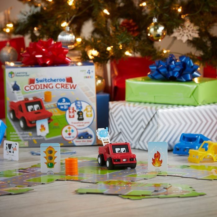 Toy truck drives on puzzle road, surrounded by colorful presents and a Christmas tree. Box reads 