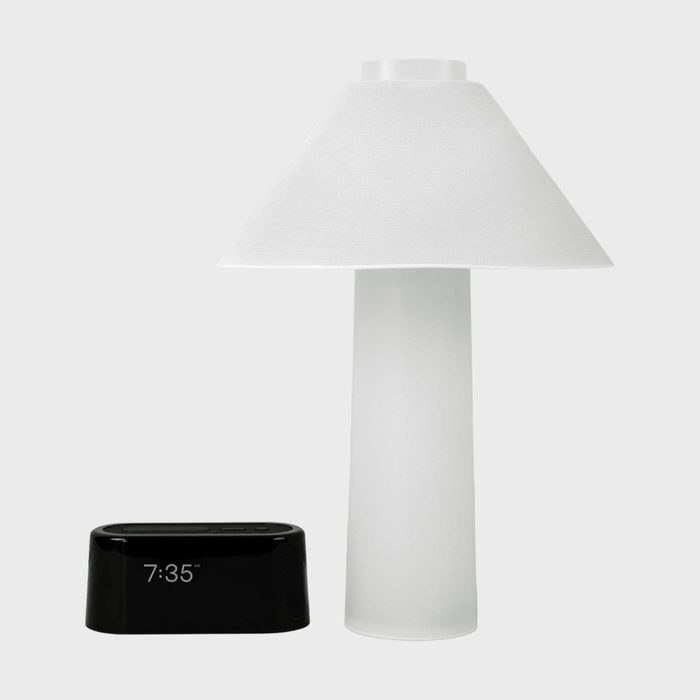 Lamp stands next to a black digital clock displaying 