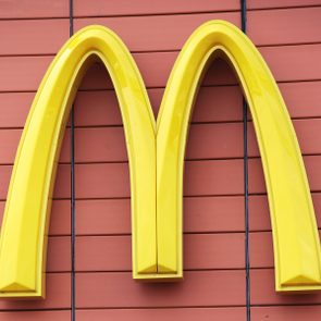 Yellow arch logo, fixed on a reddish-brown paneled wall.