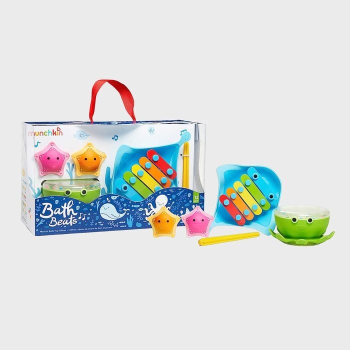 Toy set displays colorful bath instruments, including xylophone and starfish shakers, alongside packaging with ocean-themed illustrations. Text: 