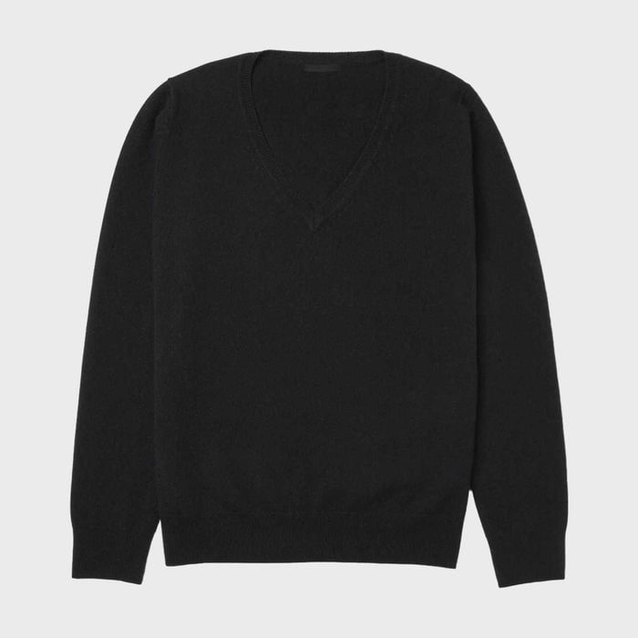 A black V-neck sweater lies flat against a plain gray background, showing its simple design and long sleeves.