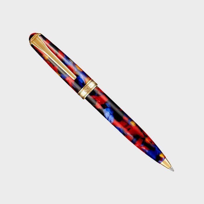 Colorful pen with gold accents lies diagonally on a plain light gray background.