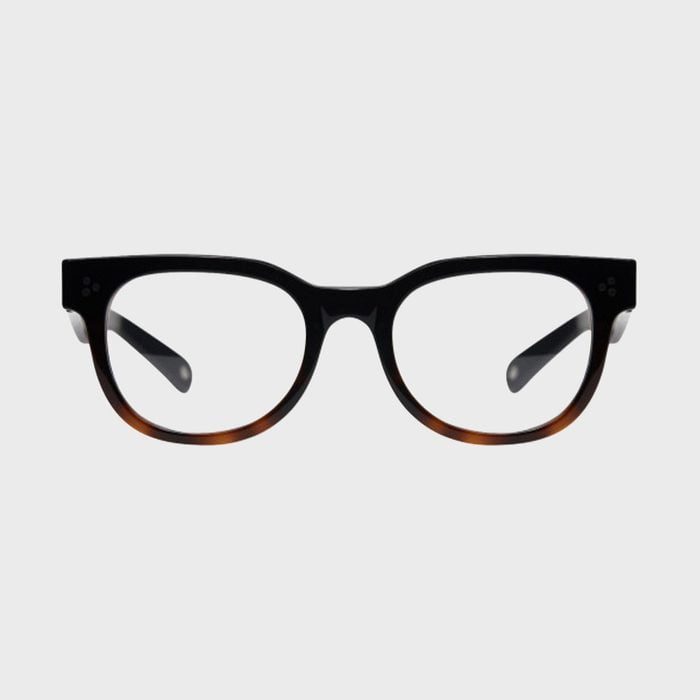 Glasses sit centered, featuring thick black frames with subtle brown accents, against a plain light gray background.