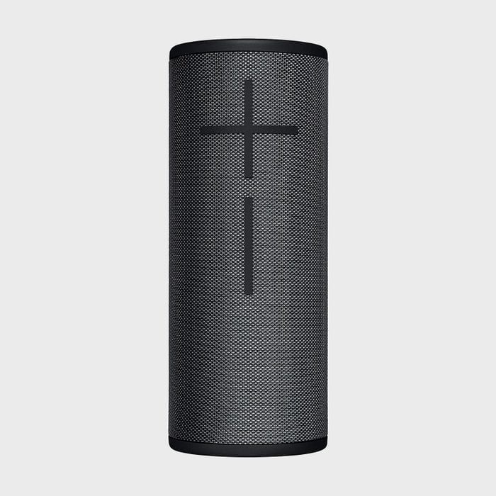 A cylindrical speaker stands upright, featuring prominent plus and minus volume symbols, set against a plain gray backdrop.