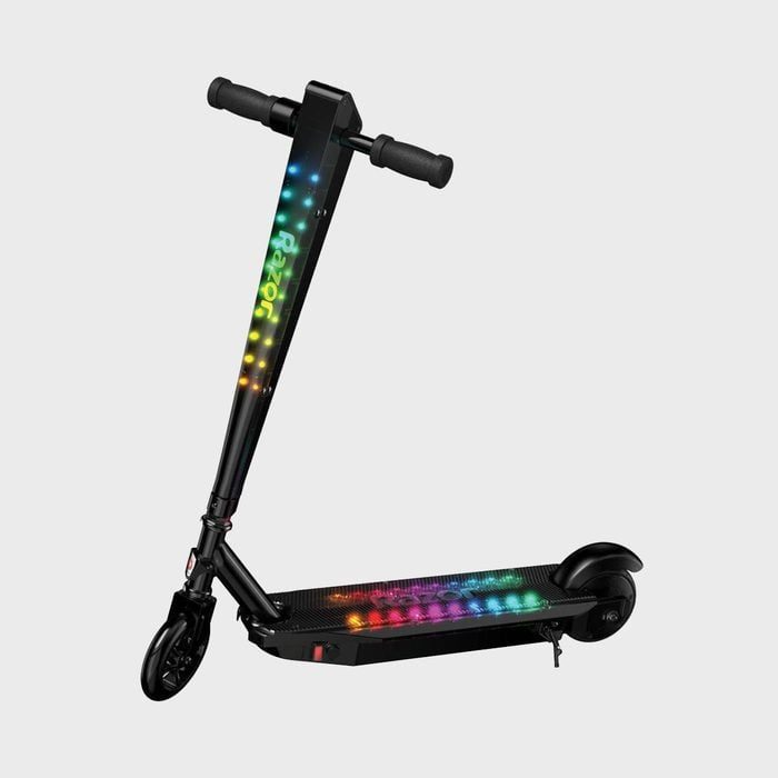Scooter displaying colorful LED lights, stationary on a plain gray background.