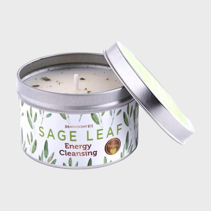 Candle sits in a metal tin with the lid slightly open, labeled 