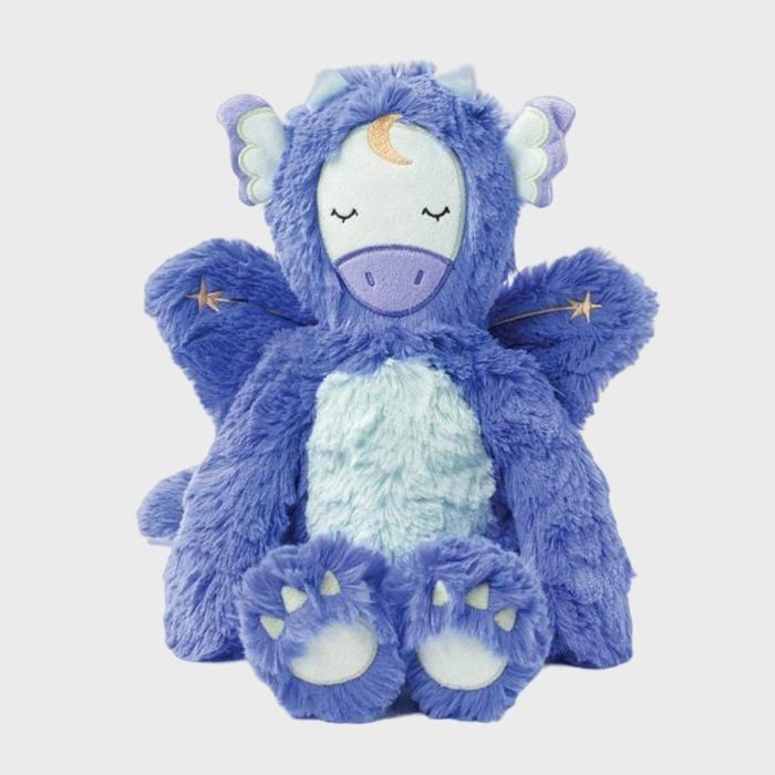 Plush dragon toy sits upright, eyes closed; blue fur with white tummy and small wings, star accents; neutral white background.