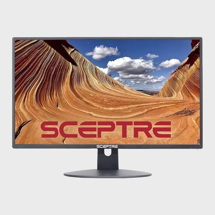Monitor displaying a desert landscape with red sandstone waves, beneath a clear blue sky and clouds; 