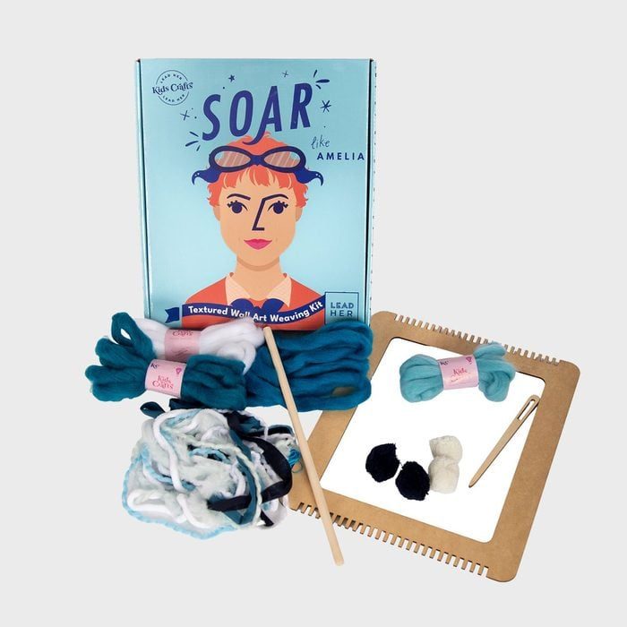Weaving kit displayed with yarn and tools in front of a box featuring an illustrated woman. Text reads: 