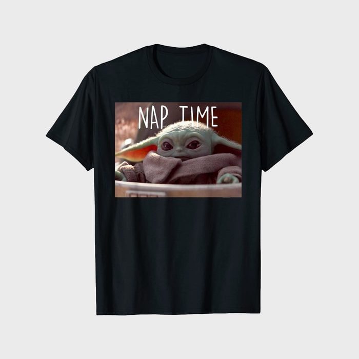 T-shirt displays a small green character bundled in a blanket, with text 
