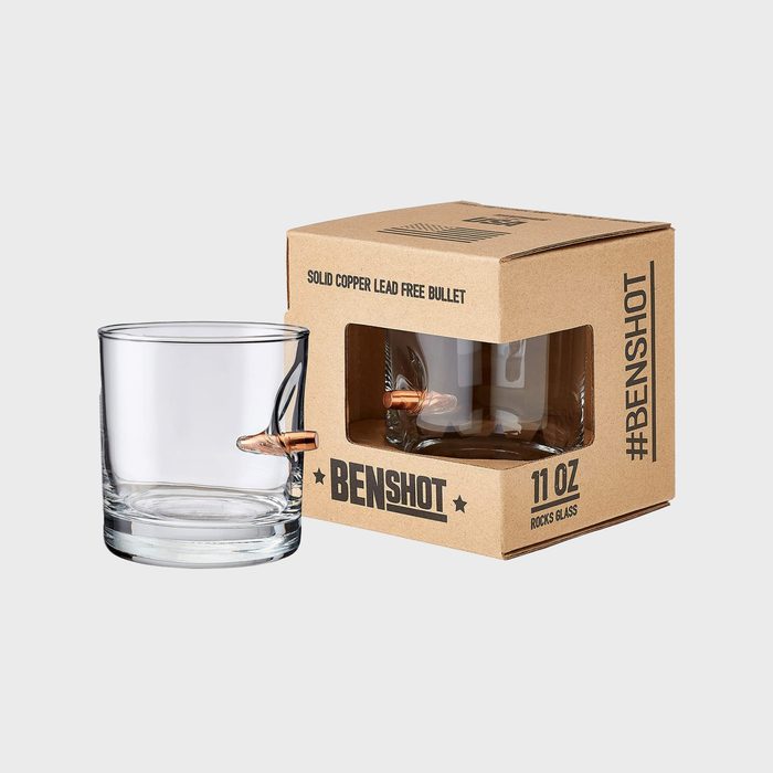 Glass with embedded copper bullet, sitting beside its cardboard packaging labeled 
