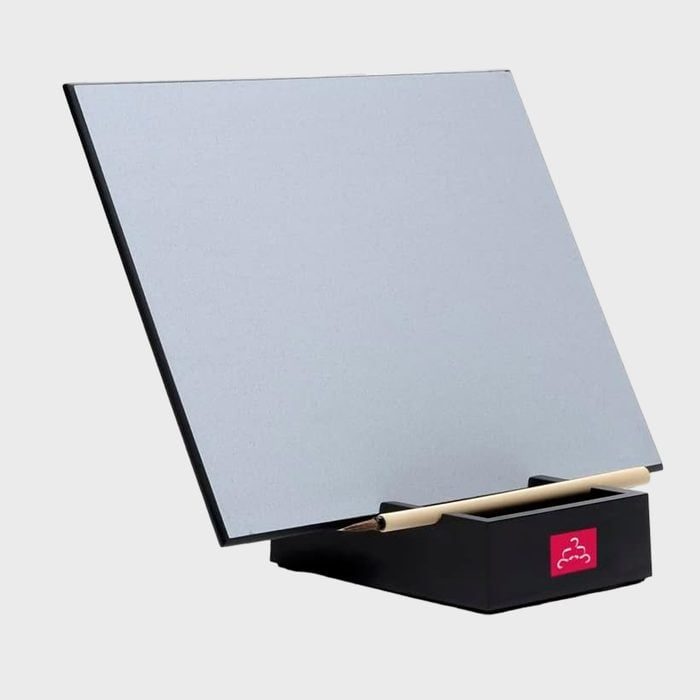 A blank water drawing board stands upright on a black base, with a brush resting in front, against a plain backdrop.
