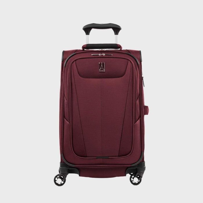 A maroon suitcase stands upright with extended handle and four wheels, set against a plain gray background.