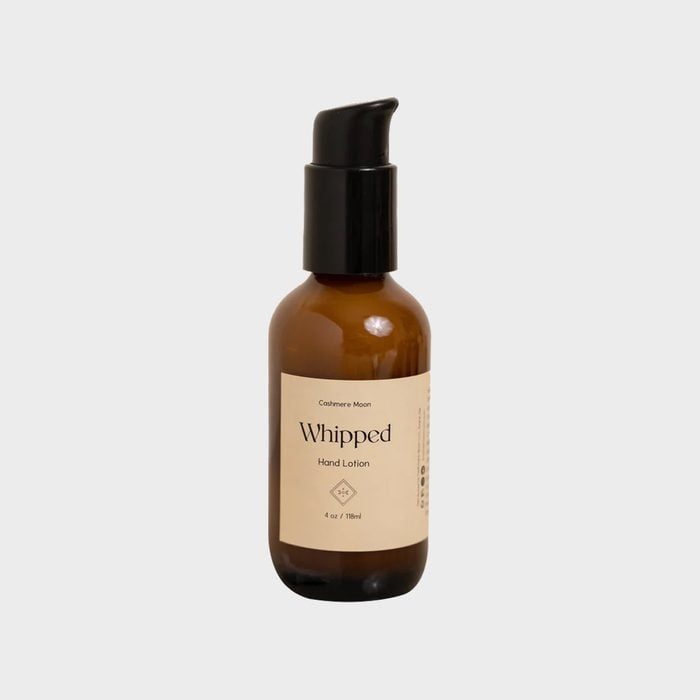 Brown bottle stands upright, dispensing hand lotion, labeled 