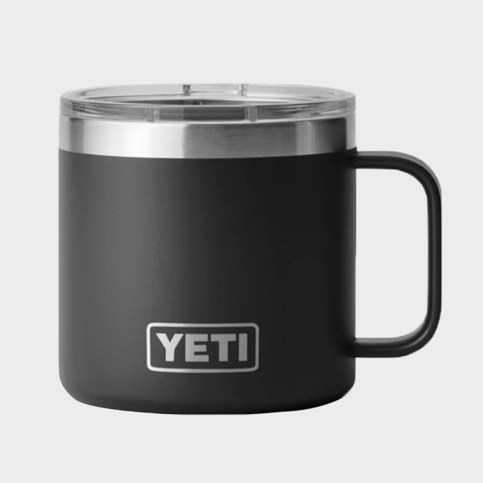 Dark tumbler cup with clear lid sitting on plain background, featuring 